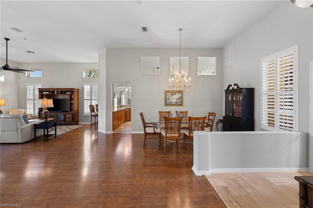 1845 Pondside Lane Naples, FL 34109 - Photo 5 of 47 a living room with furniture a wooden floor and a chandelier