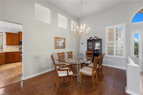 a dining room with furniture a chandelier and wooden floor