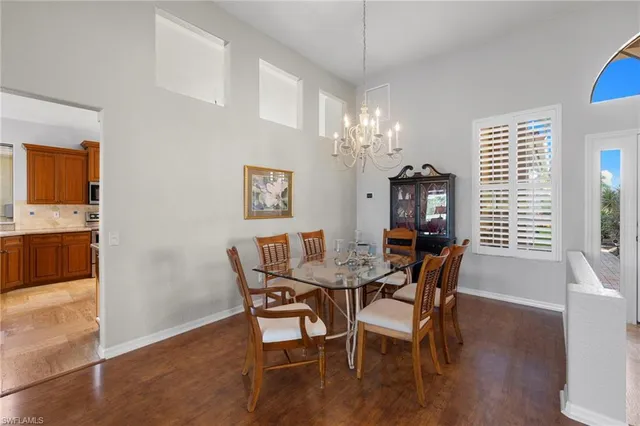 a dining room with furniture a chandelier and wooden floor