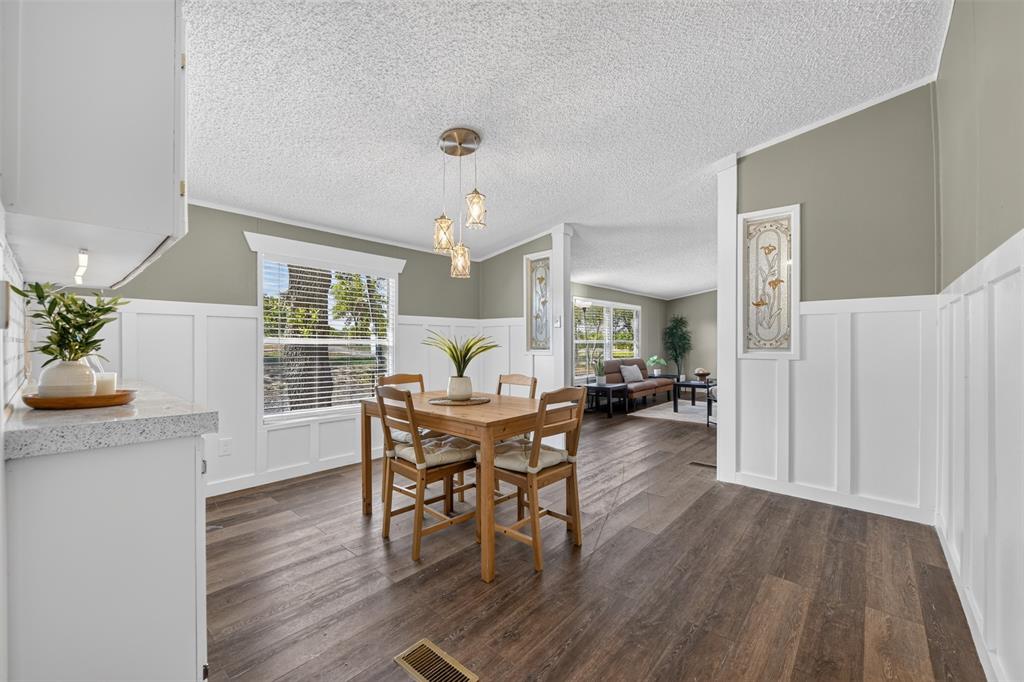 449 Big Salty Lane Springtown, TX 76082 - Photo 6 of 25 Open dining area featuring wood-finish flooring, wainscoting, and a multi-light pendant fixture