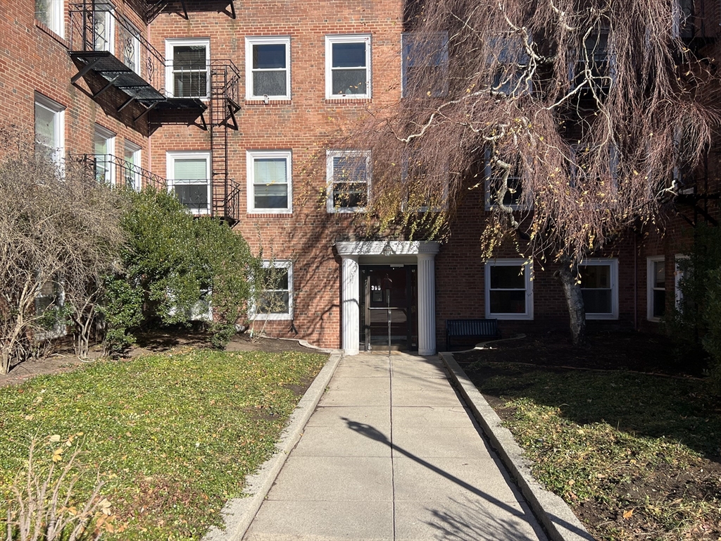 395 Broadway, Unit R2C Cambridge, MA 02139 - Photo 24 of 26 a front view of a house with a yard