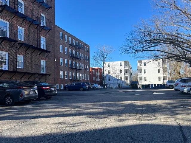 a view of a building and car parked on the street