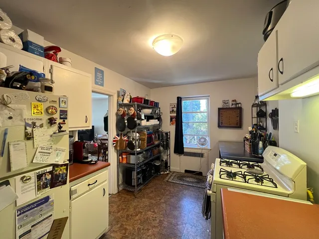 a kitchen that has a lot of cabinets a sink and appliances