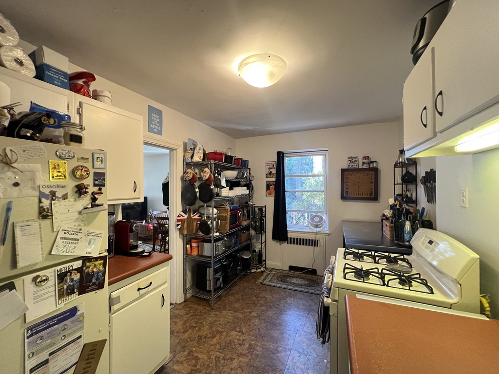 395 Broadway, Unit R2C Cambridge, MA 02139 - Photo 6 of 26 a kitchen that has a lot of cabinets a sink and appliances
