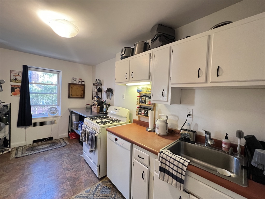 395 Broadway, Unit R2C Cambridge, MA 02139 - Photo 7 of 26 a kitchen with a sink stove and cabinets