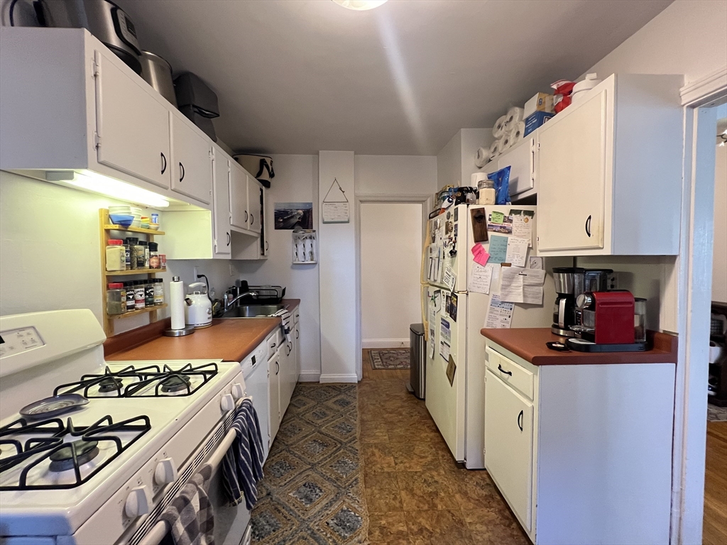 395 Broadway, Unit R2C Cambridge, MA 02139 - Photo 8 of 26 a kitchen with stainless steel appliances a sink a stove and a refrigerator