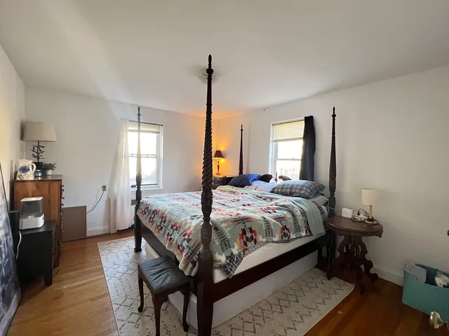 a bedroom with a bed table and a window
