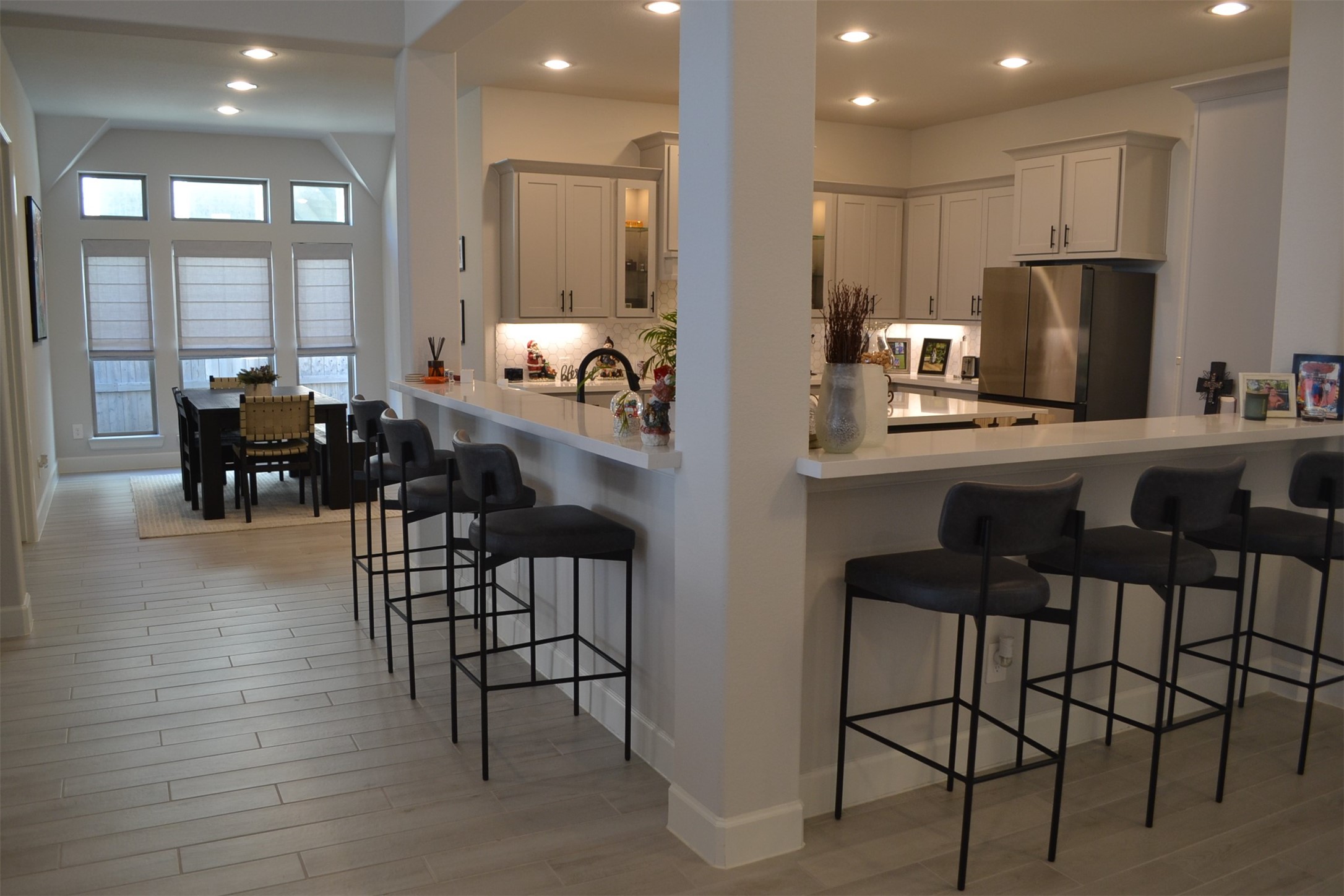 15460 Ringbill Way Magnolia, TX 77354 - Photo 16 of 50 a kitchen with kitchen island a dining table chairs and white cabinets