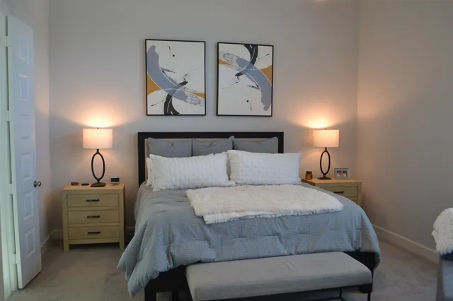 a bedroom with a bed and a painting on the wall