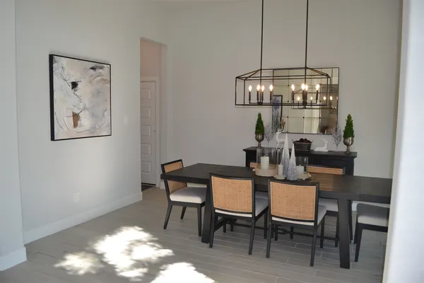 a dining room with furniture a chandelier and wooden floor
