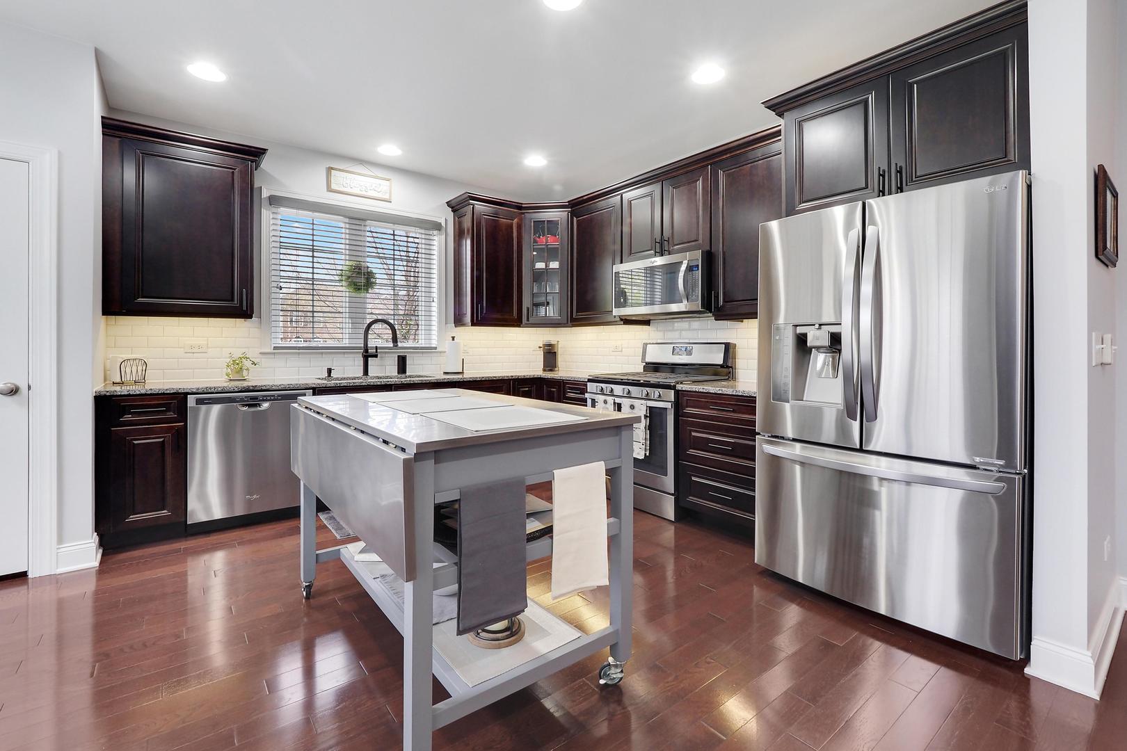 1266 Falcon Ridge Drive Elgin, IL 60124 - Photo 7 of 28 a kitchen with kitchen island a sink appliances and cabinets