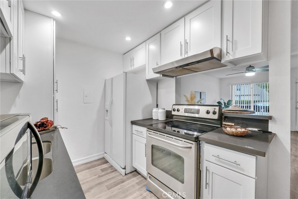 1030 West MacArthur Boulevard, Unit 5 Santa Ana, CA 92707 - Photo 11 of 26 a kitchen with stainless steel appliances granite countertop a stove a refrigerator and a cabinets