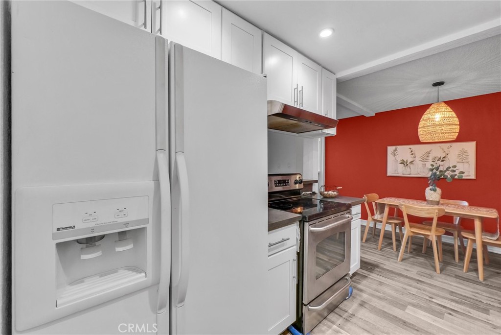 1030 West MacArthur Boulevard, Unit 5 Santa Ana, CA 92707 - Photo 12 of 26 a kitchen with stainless steel appliances a stove a refrigerator and wooden cabinets