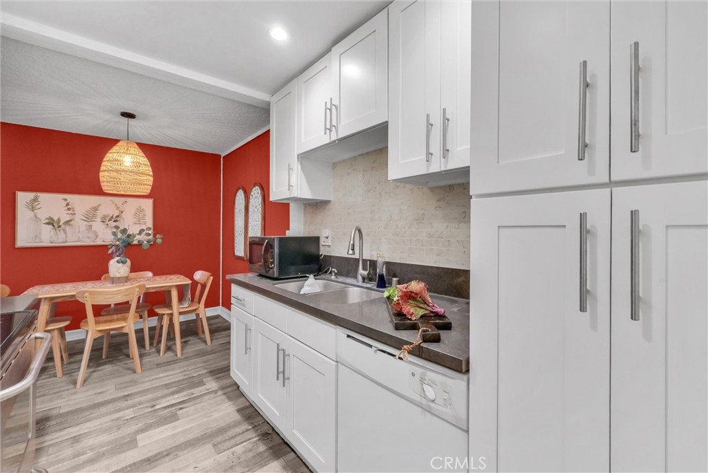 1030 West MacArthur Boulevard, Unit 5 Santa Ana, CA 92707 - Photo 13 of 26 a kitchen with stainless steel appliances kitchen island granite countertop a table chairs sink and cabinets