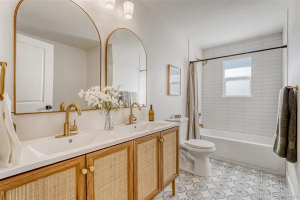 a bathroom with a double vanity sink toilet and shower