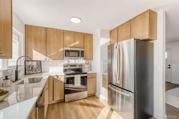 a kitchen with stainless steel appliances granite countertop a refrigerator stove and sink