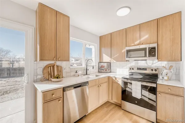 a kitchen with stainless steel appliances granite countertop a sink stove and cabinets