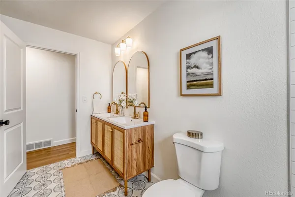 a bathroom with 2 sink toilet and a mirror