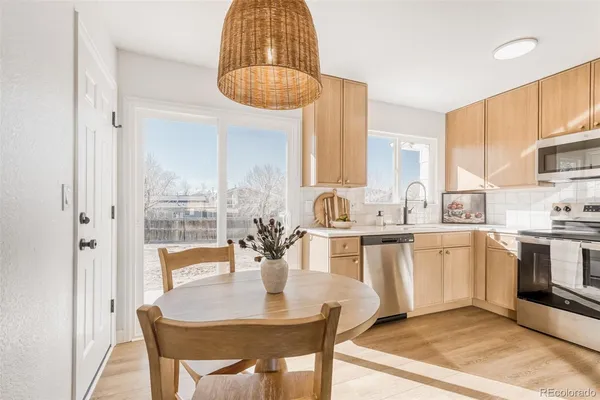 a kitchen with a dining table chairs and white cabinets