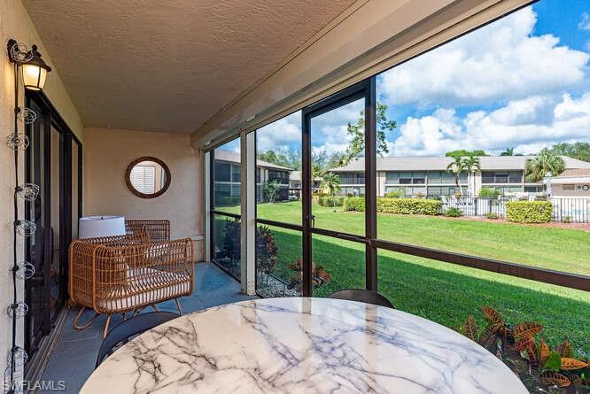252 Pebble Beach Circle, Unit C103 Naples, FL 34113 - Photo 8 of 13 a view of a porch with furniture and garden