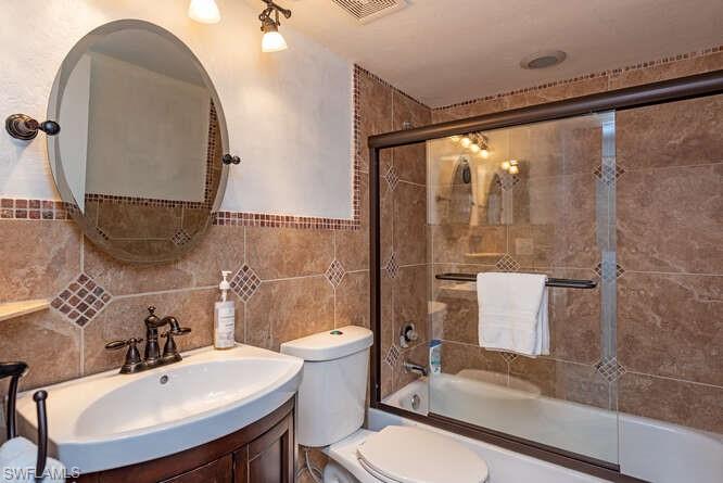 252 Pebble Beach Circle, Unit C103 Naples, FL 34113 - Photo 10 of 13 a bathroom with a sink mirror toilet and shower