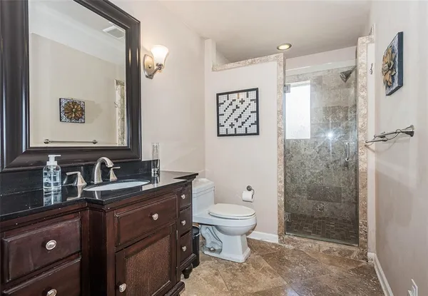 a bathroom with a granite countertop sink toilet and shower