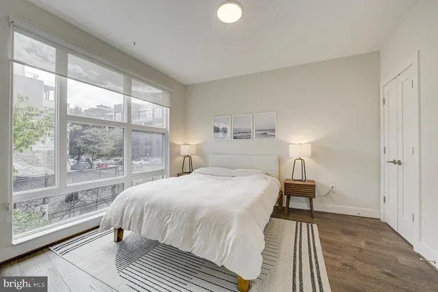 a bedroom with a bed and a large window