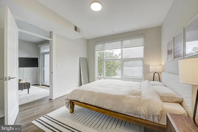 a bedroom with a bed and large window with chair