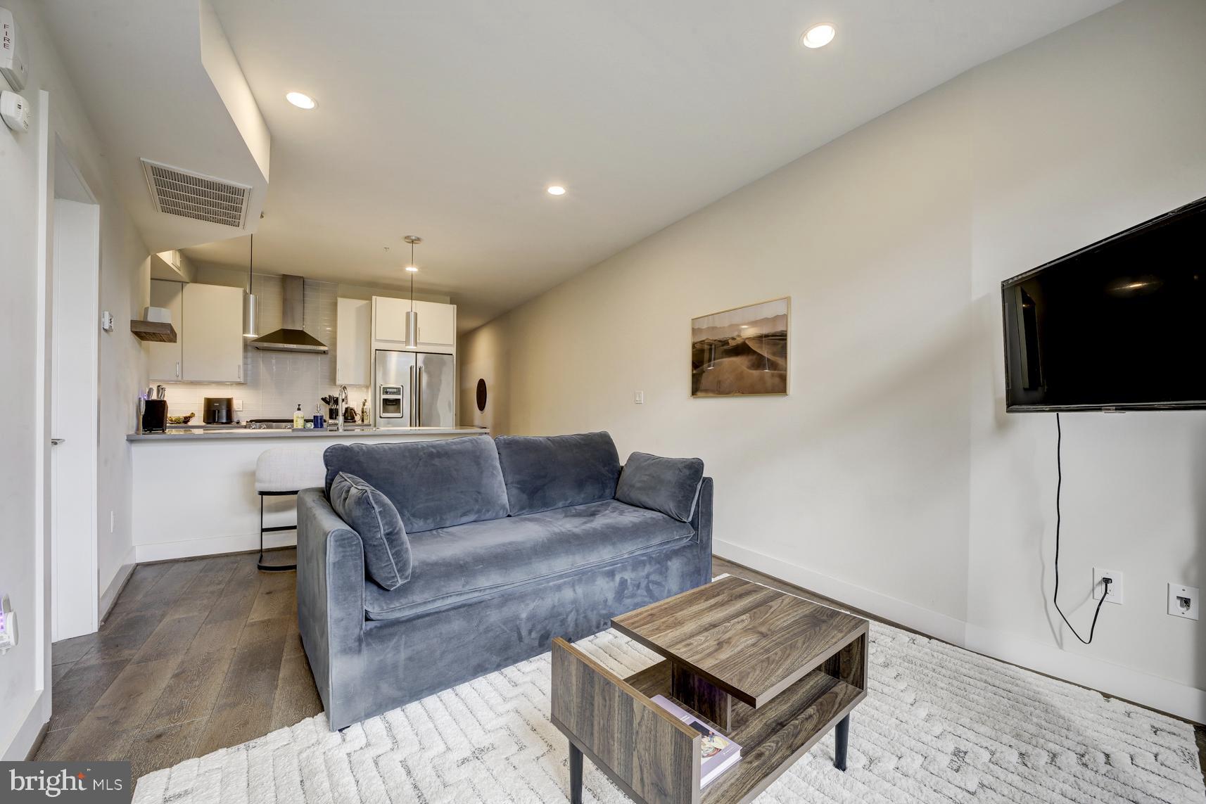 2337 Champlain Street Northwest, Unit 104 Washington, DC 20009 - Photo 4 of 29 a living room with a couch and a flat screen tv