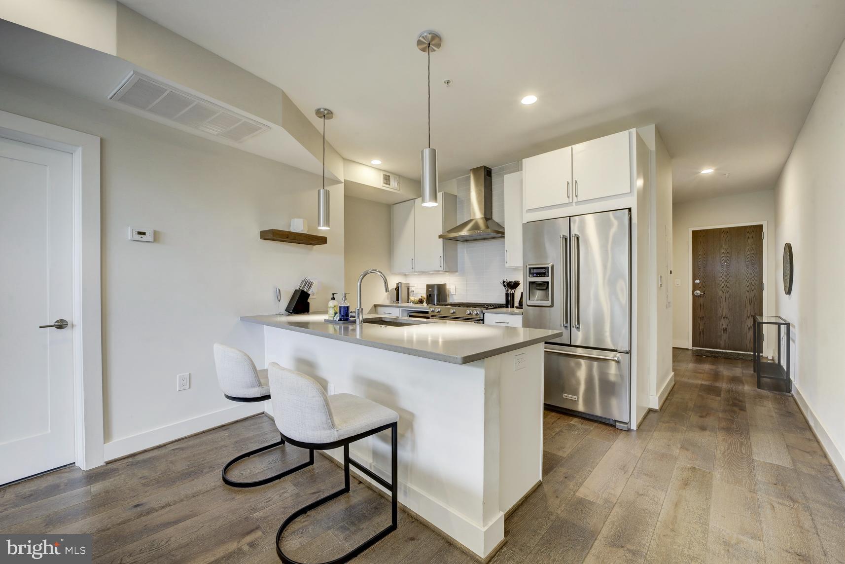 2337 Champlain Street Northwest, Unit 104 Washington, DC 20009 - Photo 9 of 29 a kitchen with refrigerator cabinets and wooden floor