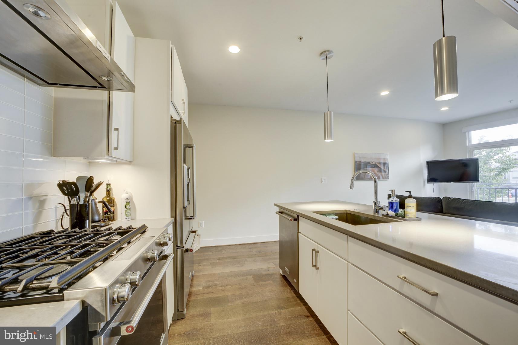 2337 Champlain Street Northwest, Unit 104 Washington, DC 20009 - Photo 10 of 29 a kitchen with stainless steel appliances granite countertop a sink a stove and a refrigerator
