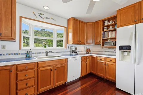 a kitchen with granite countertop stainless steel appliances a refrigerator cabinets and wooden floor