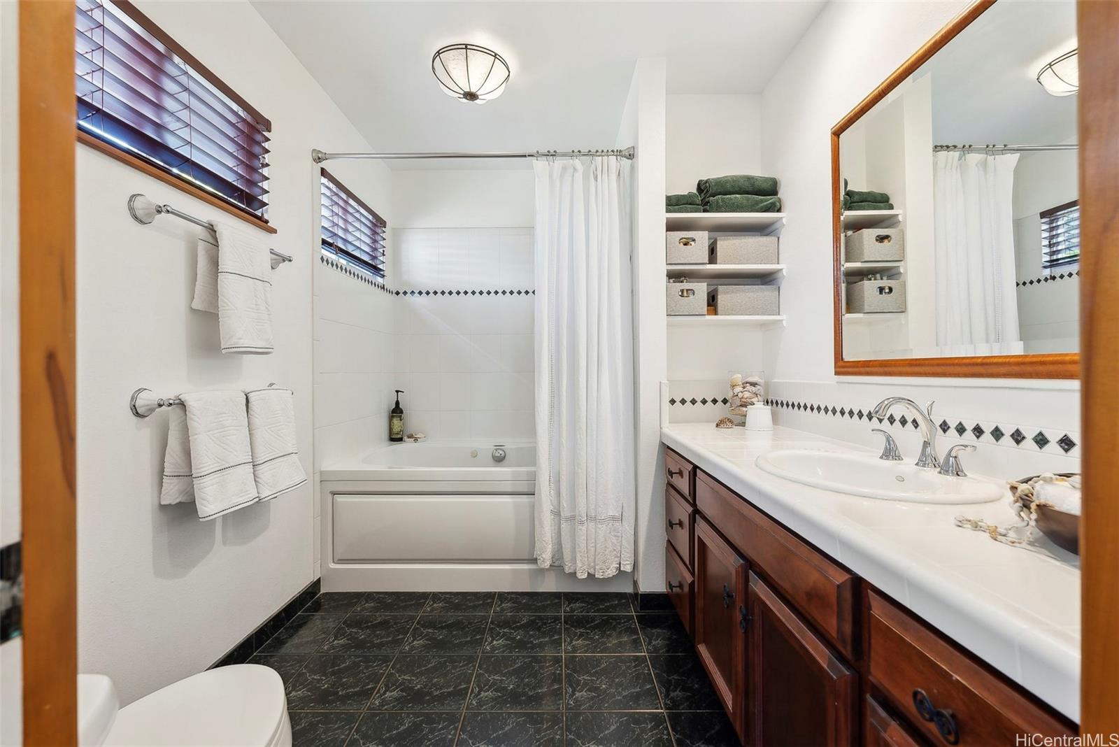 59-535 Ke Iki Road, Unit A Haleiwa, HI 96712 - Photo 19 of 25 a bathroom with a sink a toilet and a bathtub