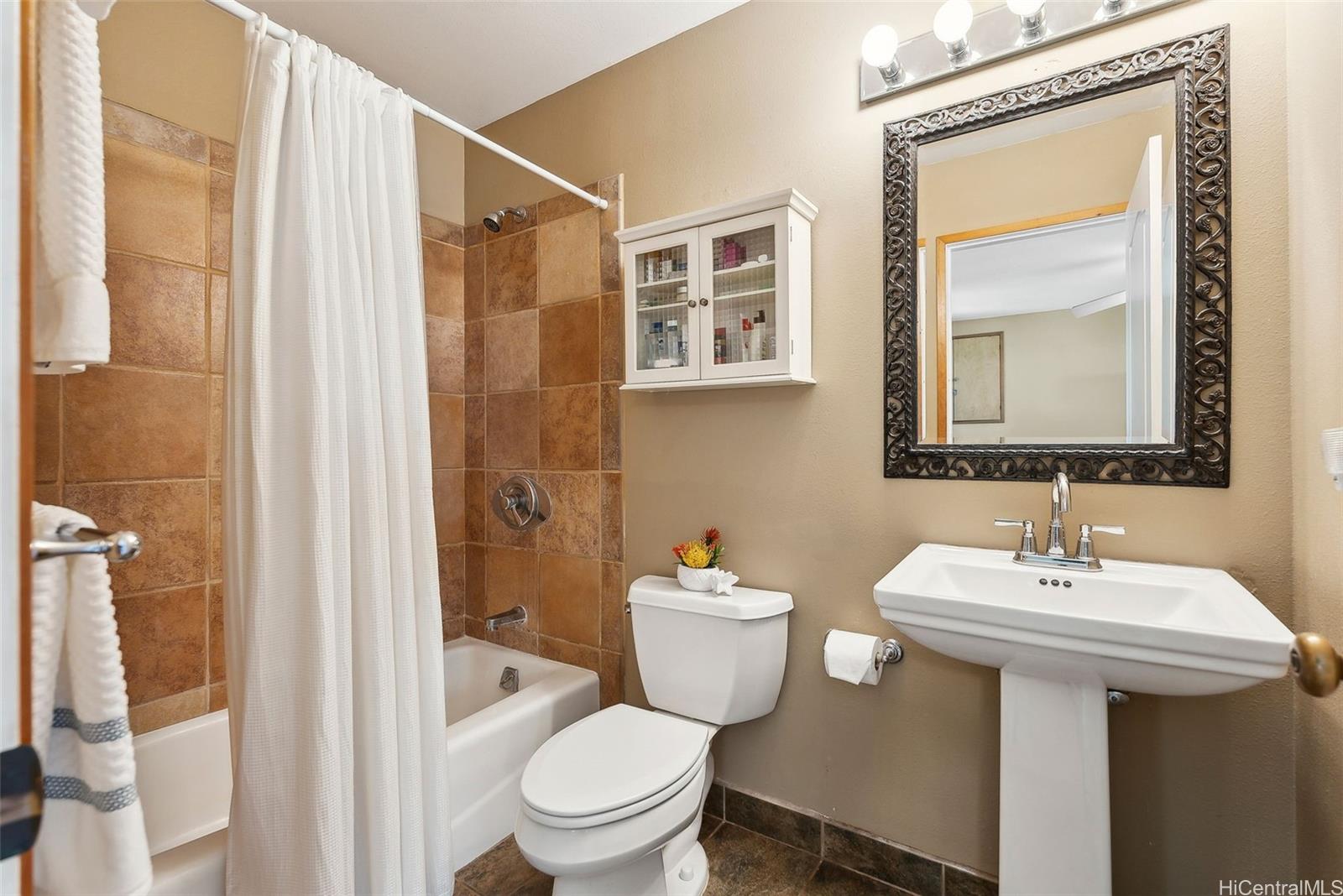 59-535 Ke Iki Road, Unit A Haleiwa, HI 96712 - Photo 21 of 25 a bathroom with a toilet sink and mirror