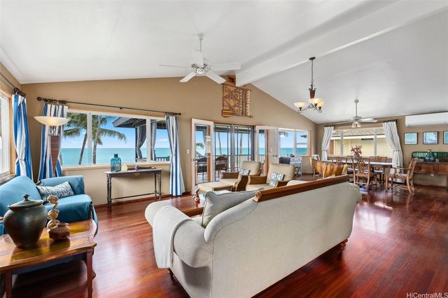 a living room with furniture a large window and wooden floor