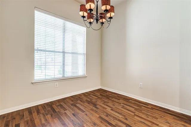 an empty room with wooden floor and a window