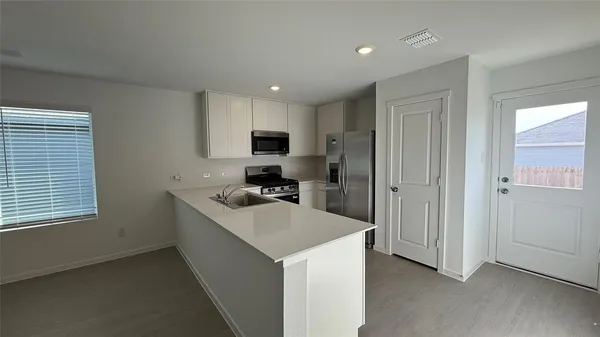 a kitchen with kitchen island a sink appliances and cabinets