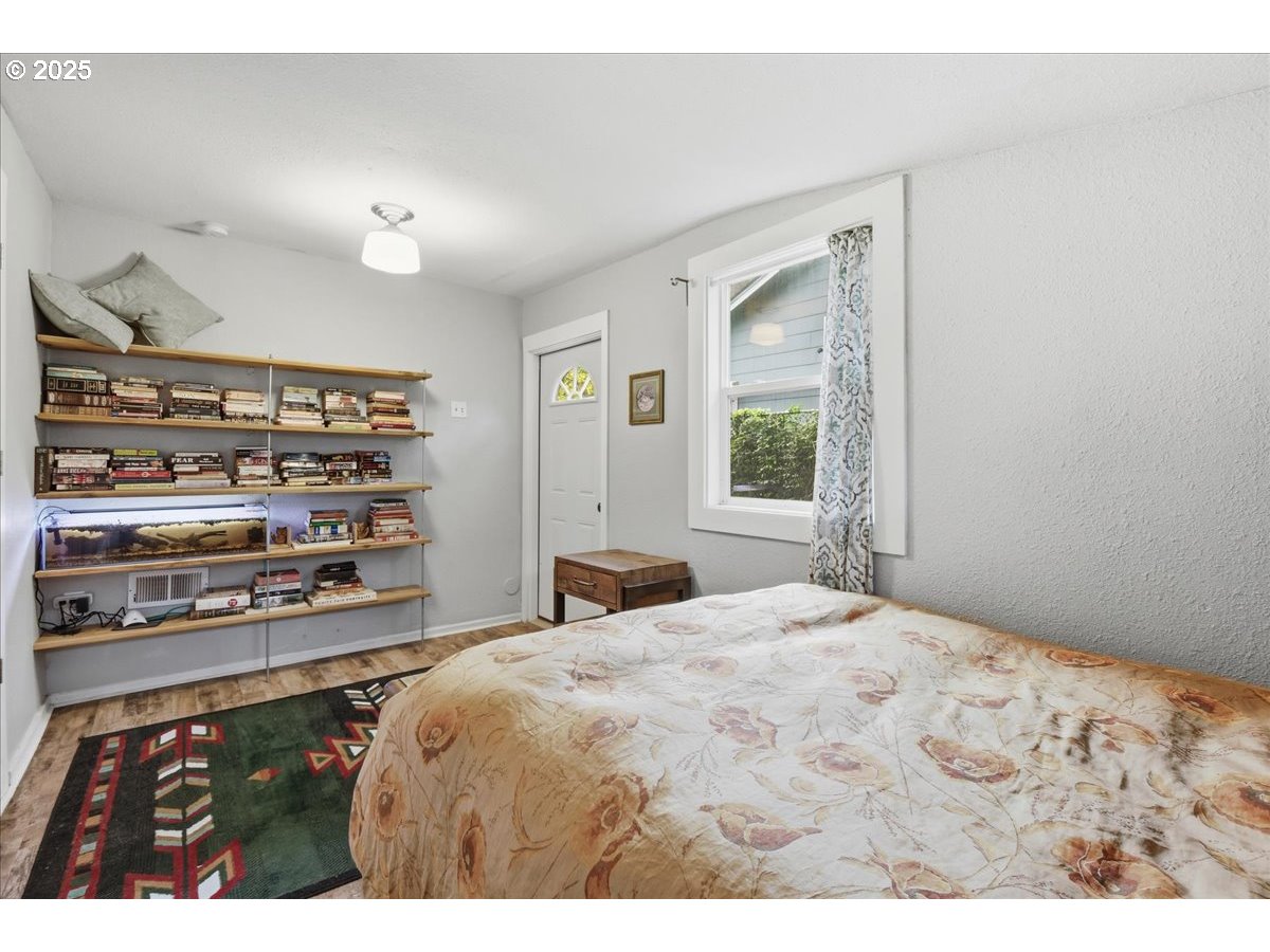 8813 Northeast Ward Street Portland, OR 97220 - Photo 13 of 32 a bedroom with a bed and a window