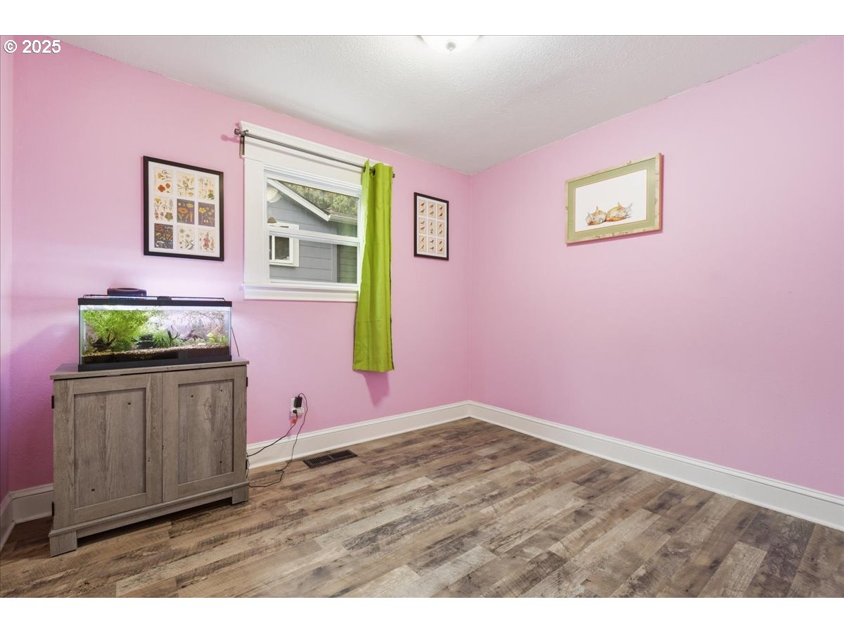 8813 Northeast Ward Street Portland, OR 97220 - Photo 16 of 32 a view of an empty room with wooden floor