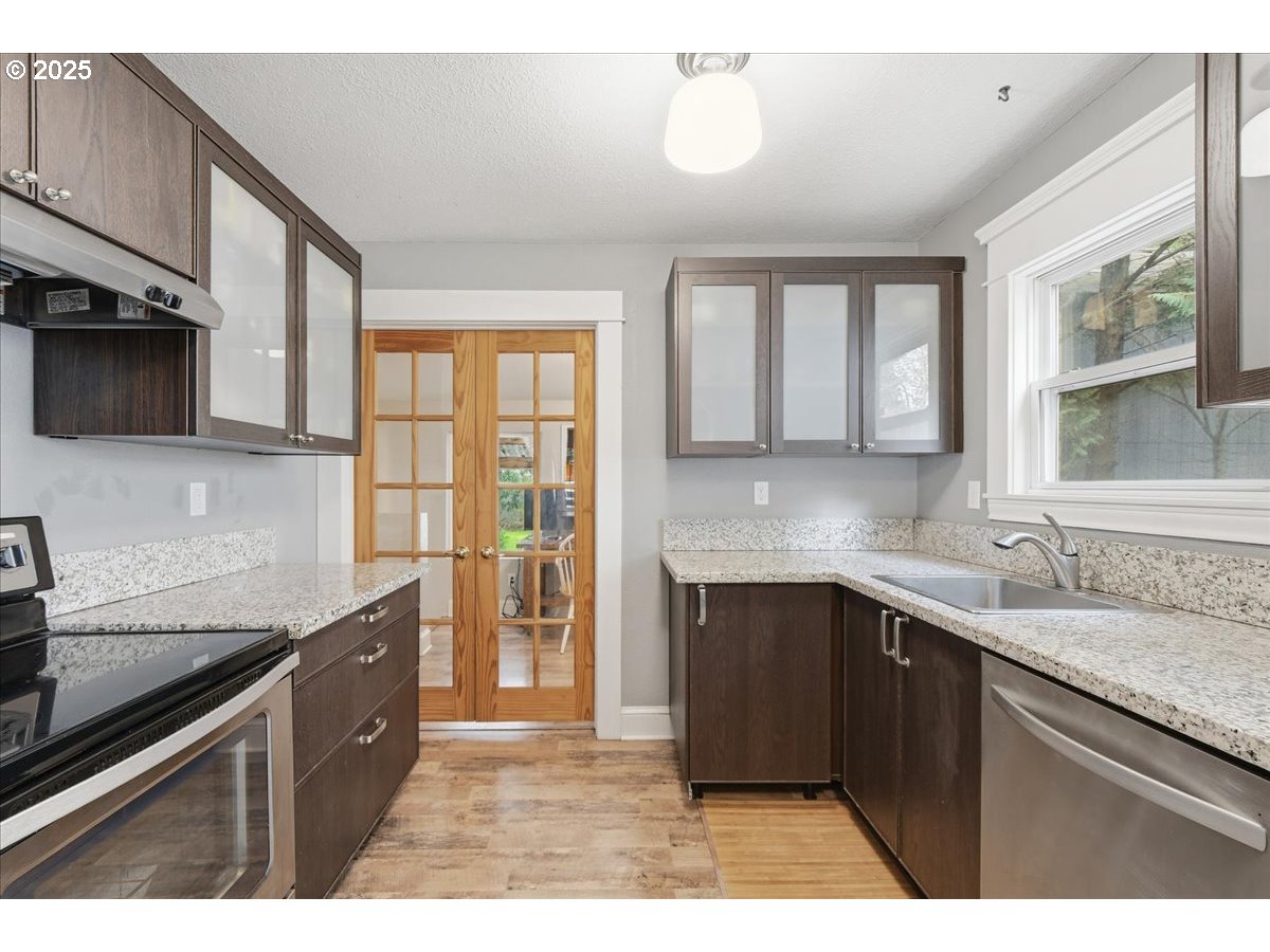 8813 Northeast Ward Street Portland, OR 97220 - Photo 9 of 32 a kitchen with a sink and a refrigerator