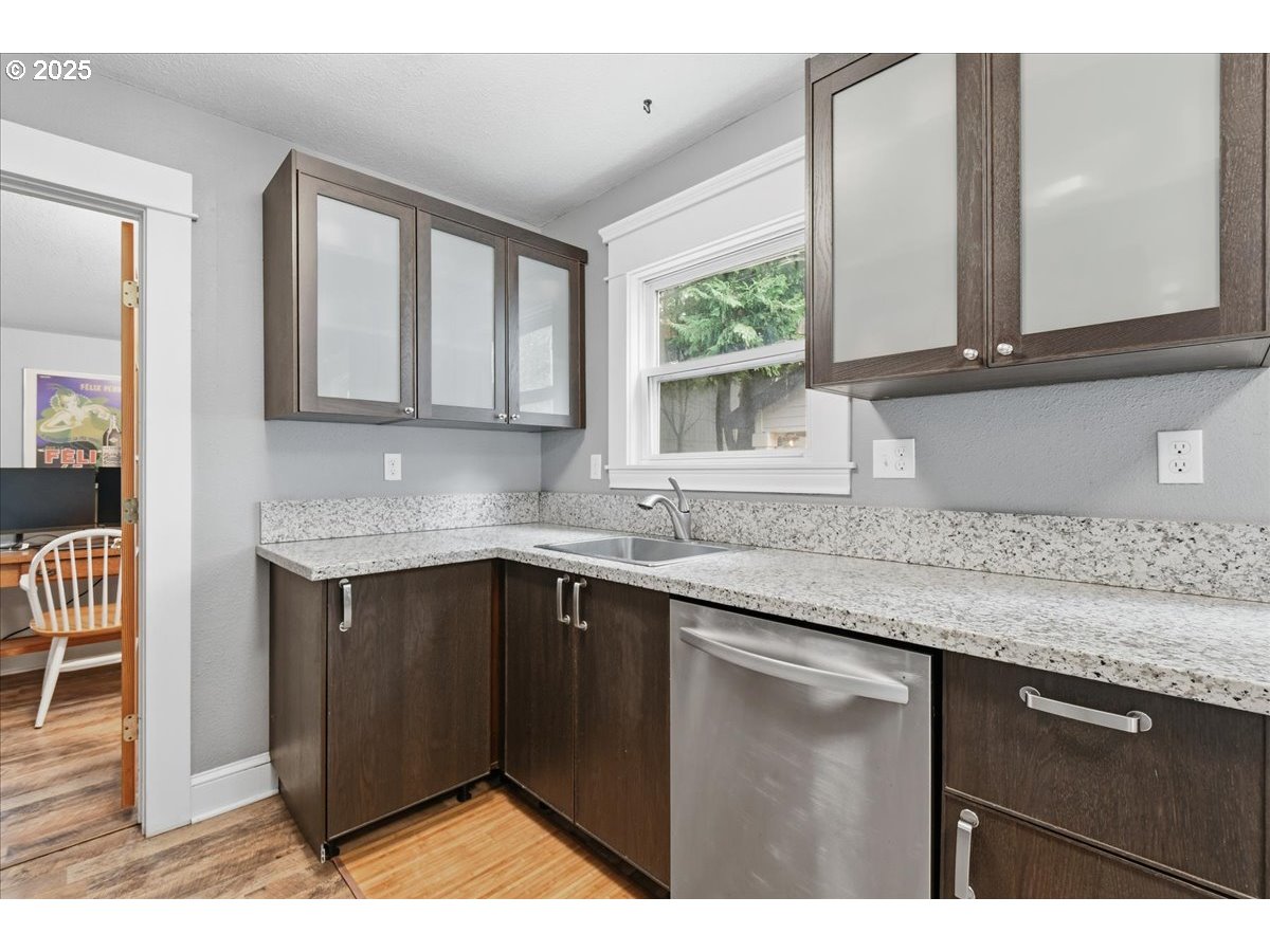 8813 Northeast Ward Street Portland, OR 97220 - Photo 10 of 32 a kitchen with granite countertop a sink and cabinets