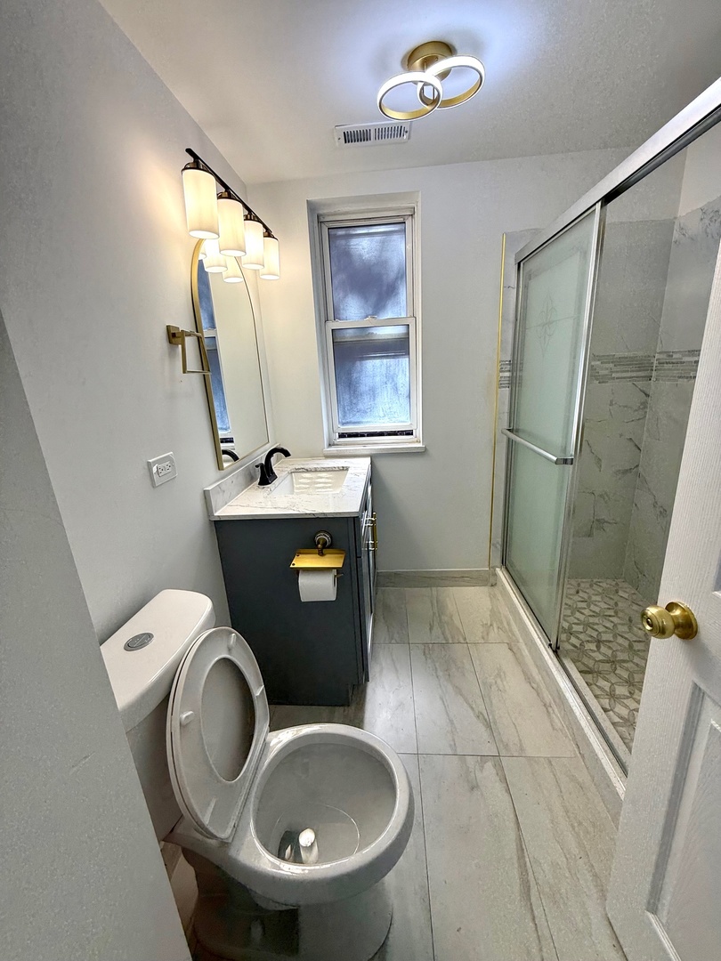 4357 South Whipple Street, Unit 2 Chicago, IL 60632 - Photo 11 of 17 a bathroom with a toilet sink and mirror