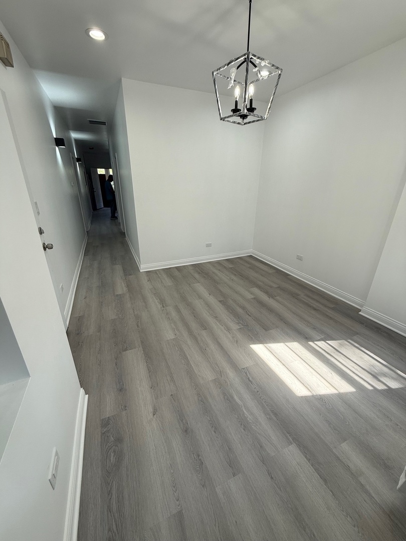 4357 South Whipple Street, Unit 2 Chicago, IL 60632 - Photo 4 of 17 a view of a room with wooden floor and ceiling fan