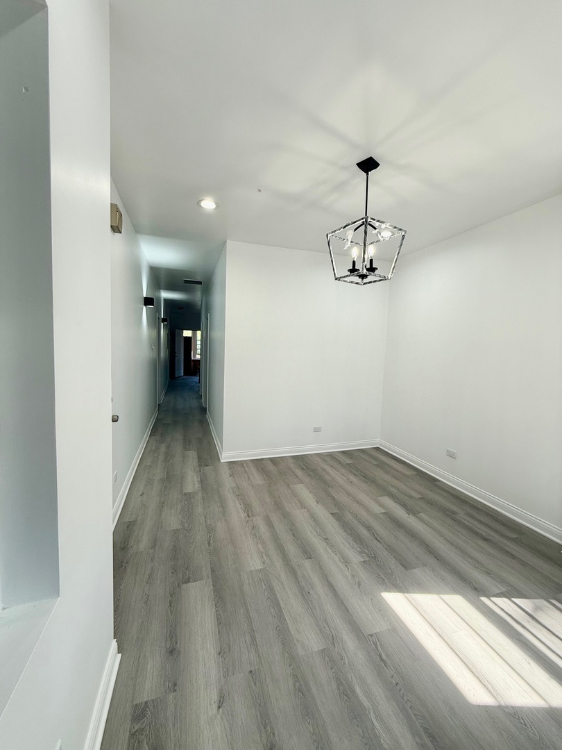 4357 South Whipple Street, Unit 2 Chicago, IL 60632 - Photo 6 of 17 a view of a room with wooden floor and ceiling fan