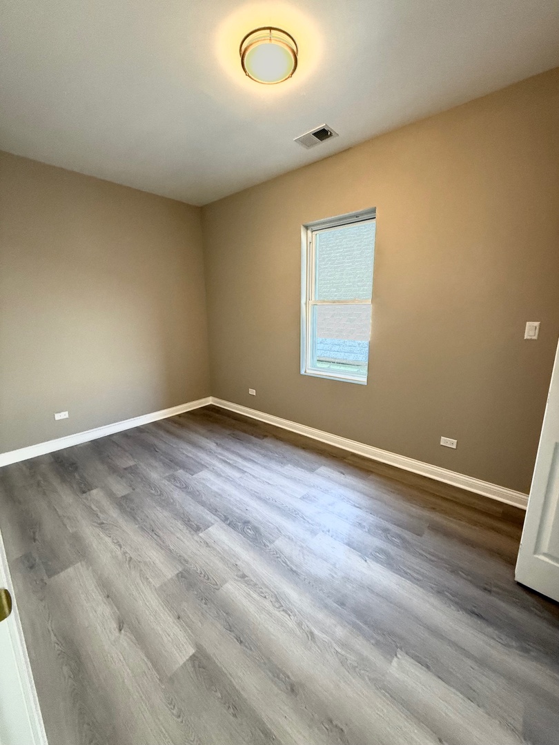 4357 South Whipple Street, Unit 2 Chicago, IL 60632 - Photo 8 of 17 an empty room with wooden floor and windows