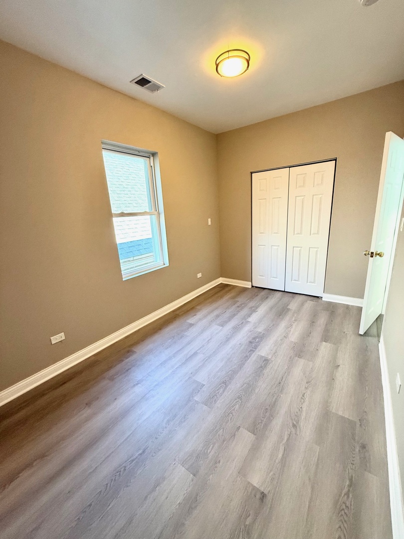 4357 South Whipple Street, Unit 2 Chicago, IL 60632 - Photo 9 of 17 a view of an empty room with wooden floor and a window