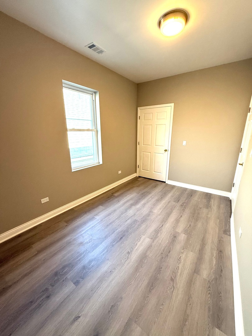 4357 South Whipple Street, Unit 2 Chicago, IL 60632 - Photo 10 of 17 an empty room with wooden floor and windows