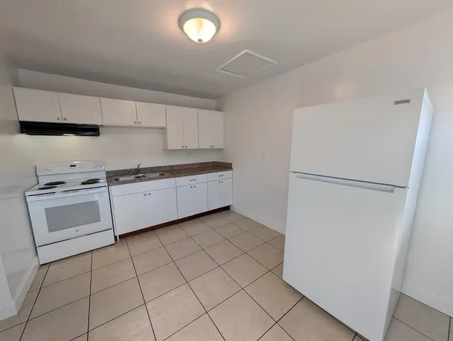 a kitchen with white cabinets and white appliances