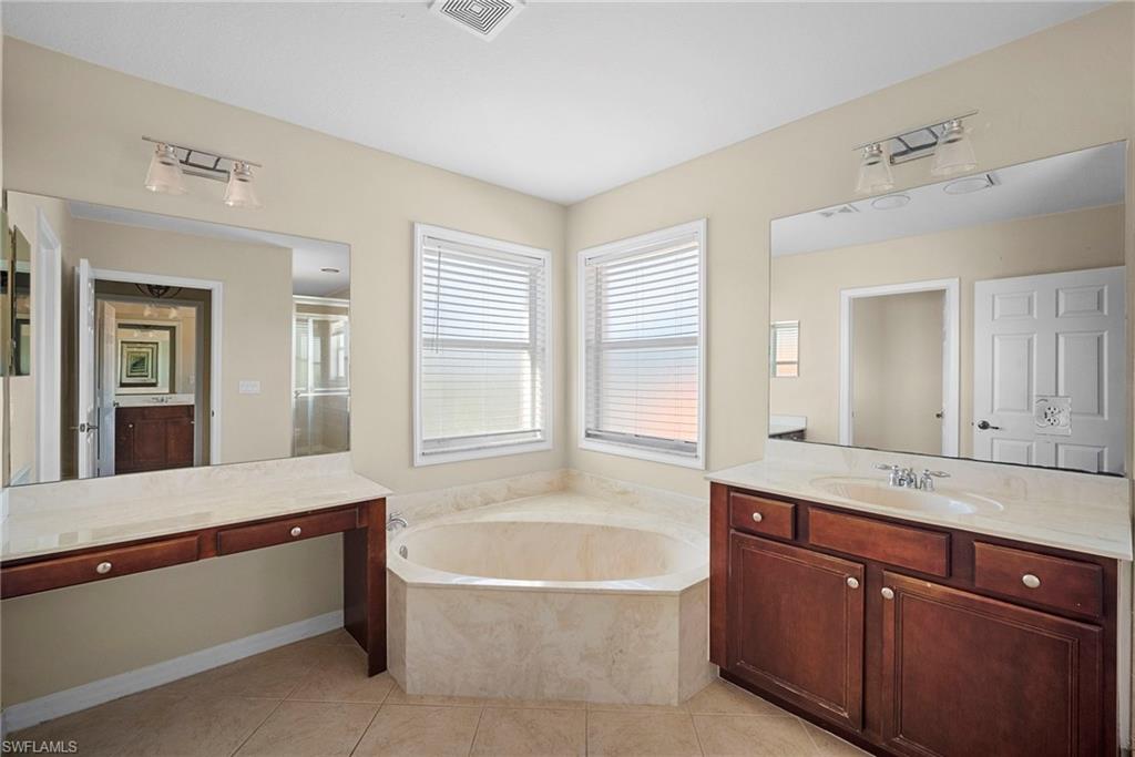 8542 Sumner Avenue, Unit 1 Fort Myers, FL 33908 - Photo 12 of 18 a bathroom with a tub a sink and a mirror
