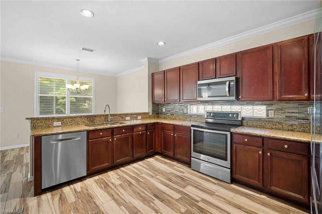 8542 Sumner Avenue, Unit 1 Fort Myers, FL 33908 - Photo 6 of 18 a kitchen with stainless steel appliances granite countertop wooden cabinets a sink and dishwasher a stove with wooden floor
